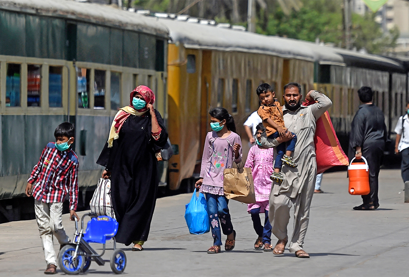 Passengers wearing facemasks walk at a railway station in Karachi, Pakistan, on April 5, 2021. (AFP/File)
