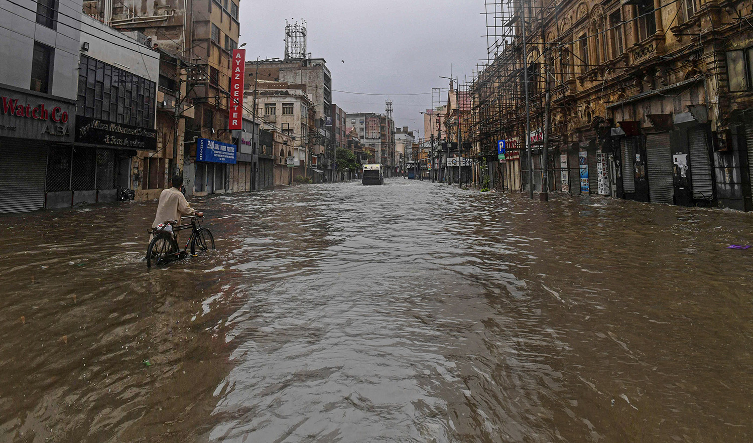 A commuter makes his way through a flooded street after a heavy rain shower in Karachi, Pakistan on July 11, 2022. (AFP)