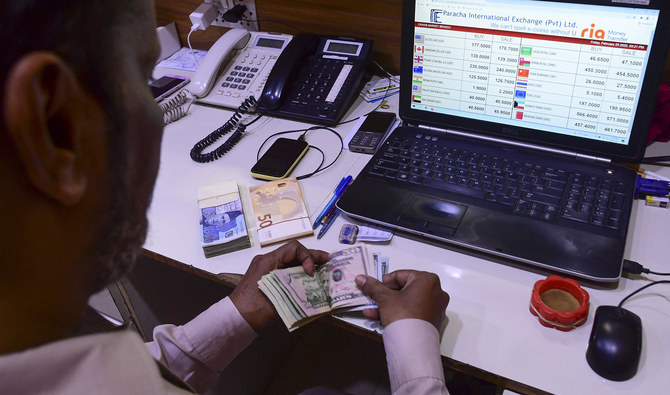 A foreign currency dealer counts US dollar bills at a shop in Karachi, Pakistan, on February 25, 2022. (AFP/File)