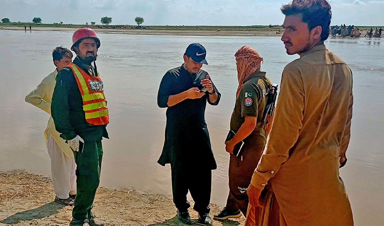 Officials coordinate an operation to recover bodies from the Indus River after a boating accident, in Sadiqabad district, about 350 kilometers (210 miles) south of Multan, Pakistan, on July 18, 2022. (AP)