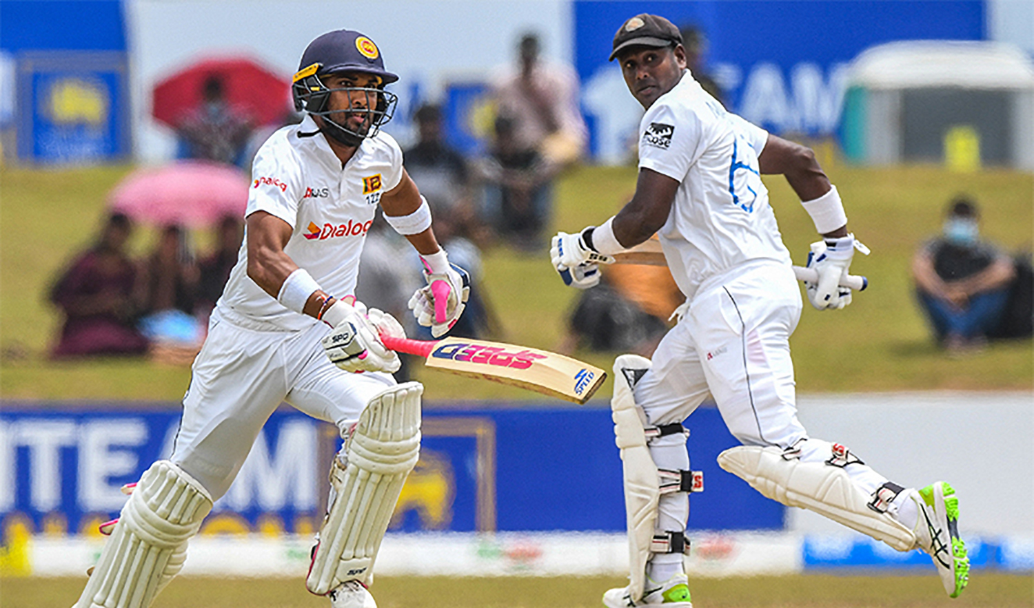 Sri Lanka's Dinesh Chandimal (L) and Angelo Mathews run between the wickets during the first day of the second cricket Test match between Sri Lanka and Pakistan in Galle on July 24, 2022. (AFP)