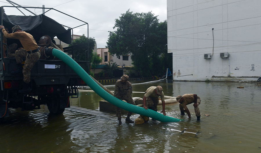 Troops use a water pump to remove water from a flooded residential area following heavy monsoon rains in Karachi on July 26, 2022. (AFP)