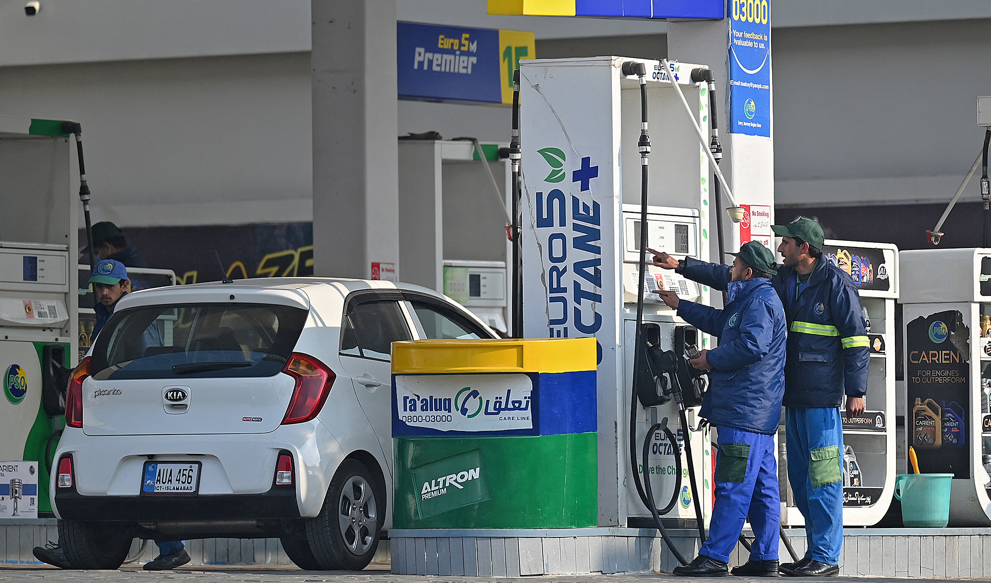 Employees at a fuel station attend to their customers in Islamabad on February 16, 2022, after a hike in prices of petroleum products. (AFP/File)
