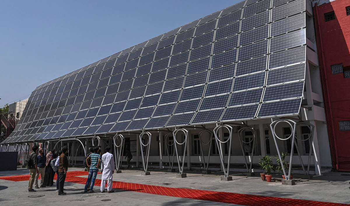 Students look at the facade of a building made with solar panels producing some 148 Kilowatts during its inauguration at the University of Engineering and Technology in Lahore on October 12, 2020. (AFP/File)