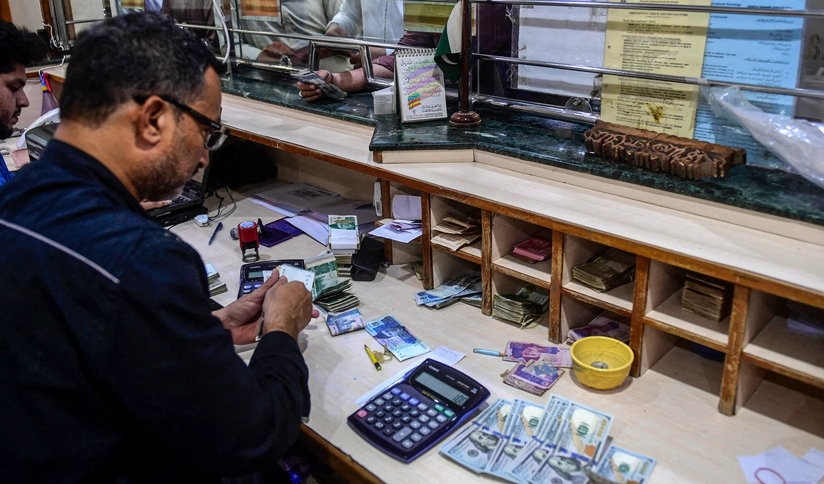 People exchange foreign currency at a shop in Karachi, Pakistan, on April 7, 2022. (AFP/File)