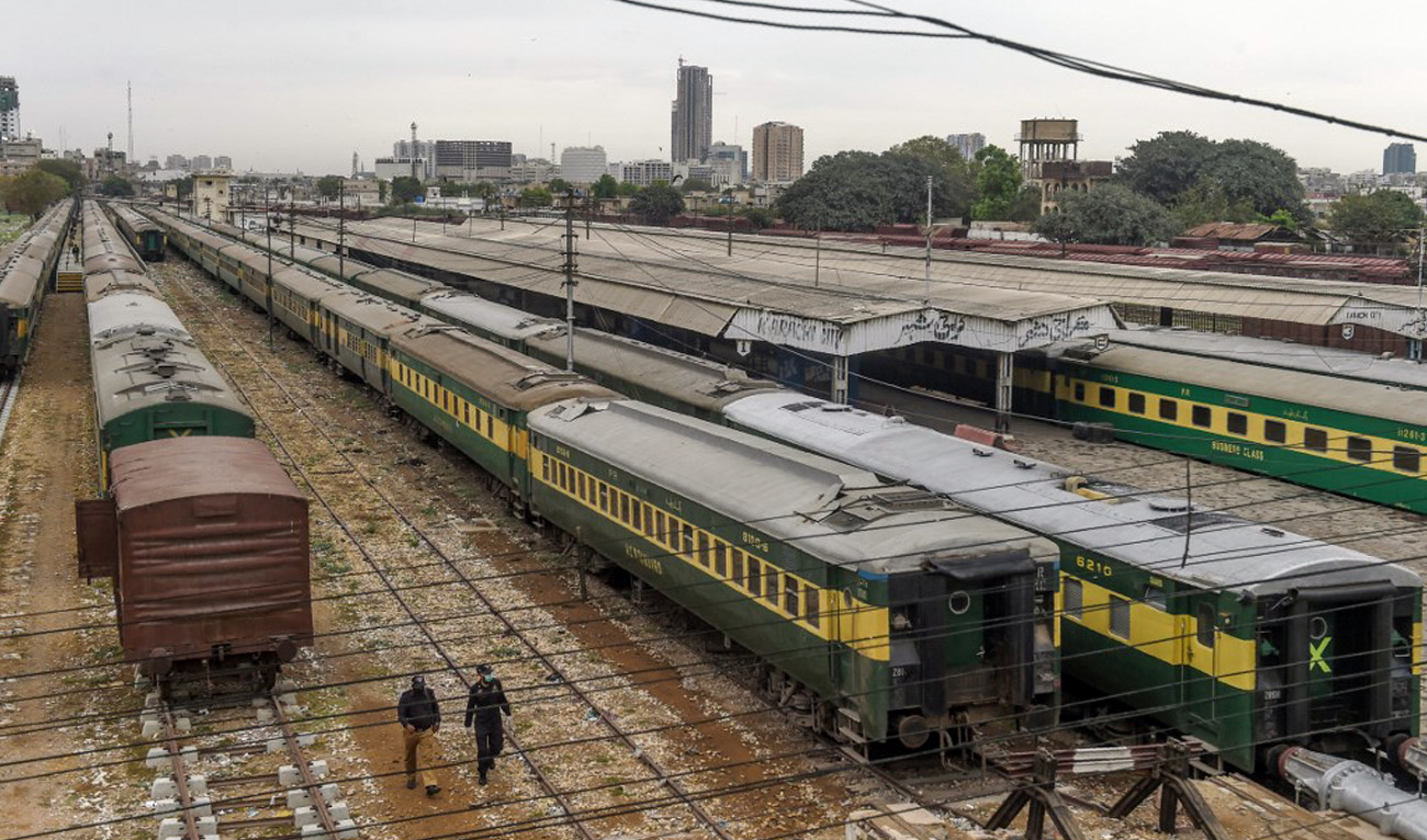 Policemen walk along trains stationed on a deserted platform at the Karachi Cantonment railway station in Karachi, Pakistan on March 26, 2020. (AFP/File)