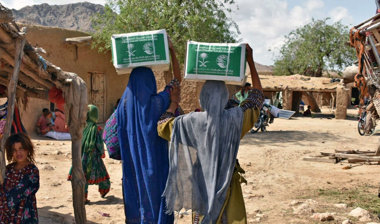 Flood affectees of Balochistan are carrying relief food packages provided by the KSRelief in Khuzdar, Pakistan on July 15, 2022. (KSRelief)