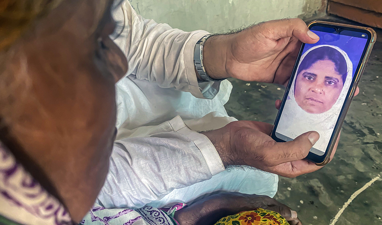 Waliullah Maroof, a local prayer leader and social activist, on August 4, 2022, shows Hamid Bano Shaikh a photograph of her on a Qatari visa from the late 1990s. The photo was shared by her family in India. (AN Photo)