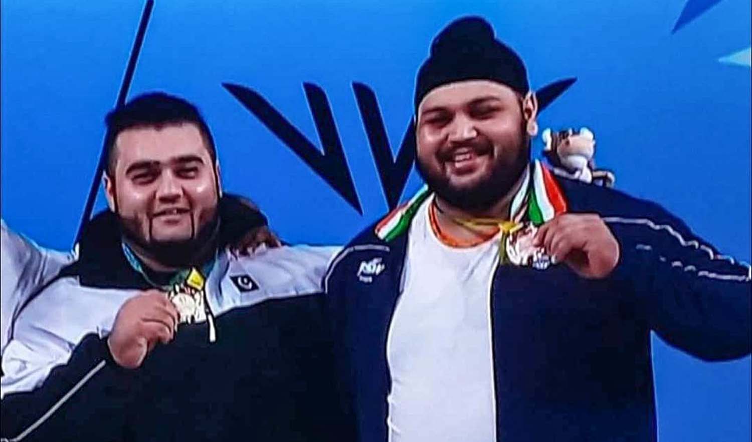 Pakistan weightlifter Nooh Dastgir Butt, left, and his Indian competitor India's Gurdeep Singh after receiving their medals at the Commonwealth Games in Birmingham, United Kingdom, on August 4, 2022. (Photo courtesy: social media)