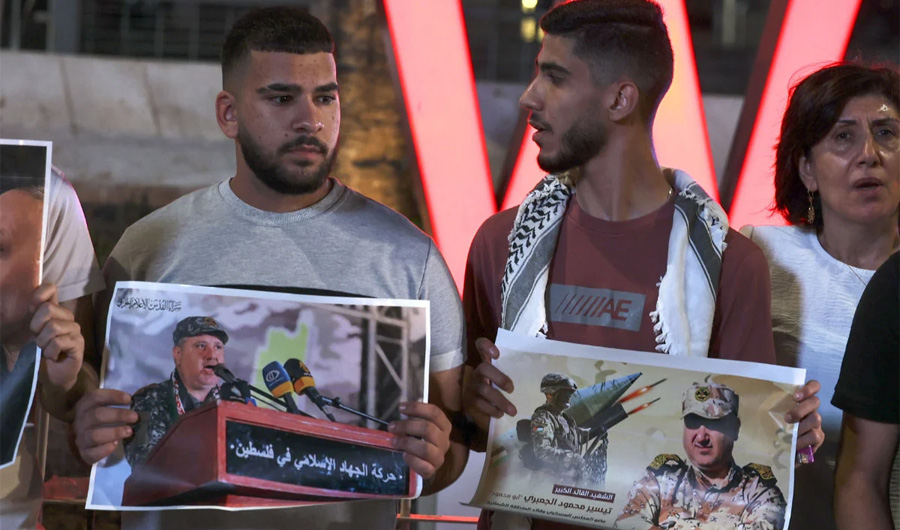 Palestinians hold placards depicting slain Islamic Jihad commander Tayseer Al-Jabari as they demonstrate in the West Bank city of Ramallah on Aug. 5, 2022 against Israeli strikes in Gaza. (AFP)