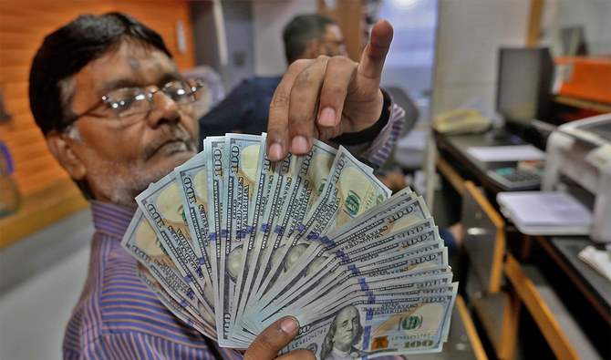 A Pakistani money trader counts U.S. dollars for a customer at a currency exchange office, in Karachi, Pakistan, on May 19, 2022. (AP/File)