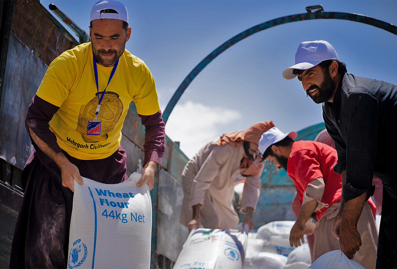 The pictures posted by World Food Programme on August 8, 2022 shows volunteers unloading wheat sacks for distribution in flood-hit areas of Pakistan. (WFP)