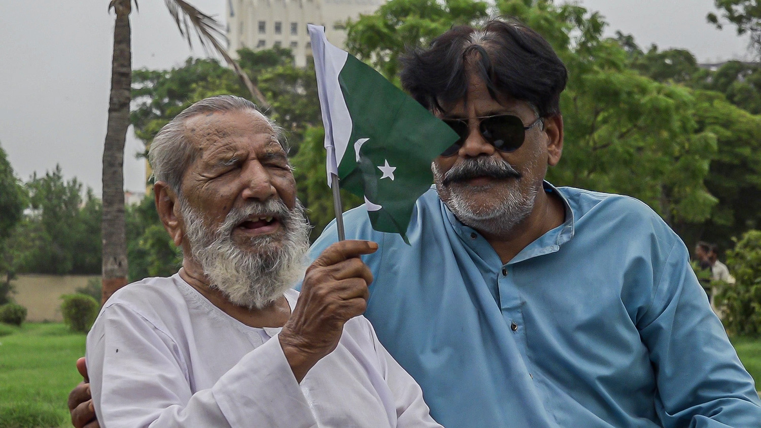 Muhammad Akram Khan, left, holds Pakistan’s flag at Frere Hall, Karachi on August 2, 2022. (AN photo)