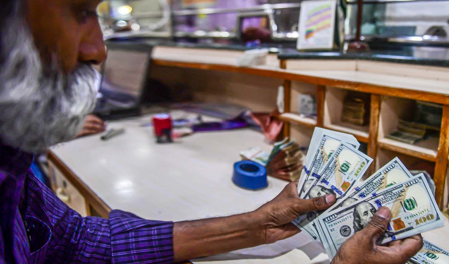 A foreign currency dealer counts US dollars at a shop in Karachi, Pakistan, on May 19, 2022. (AFP/File)