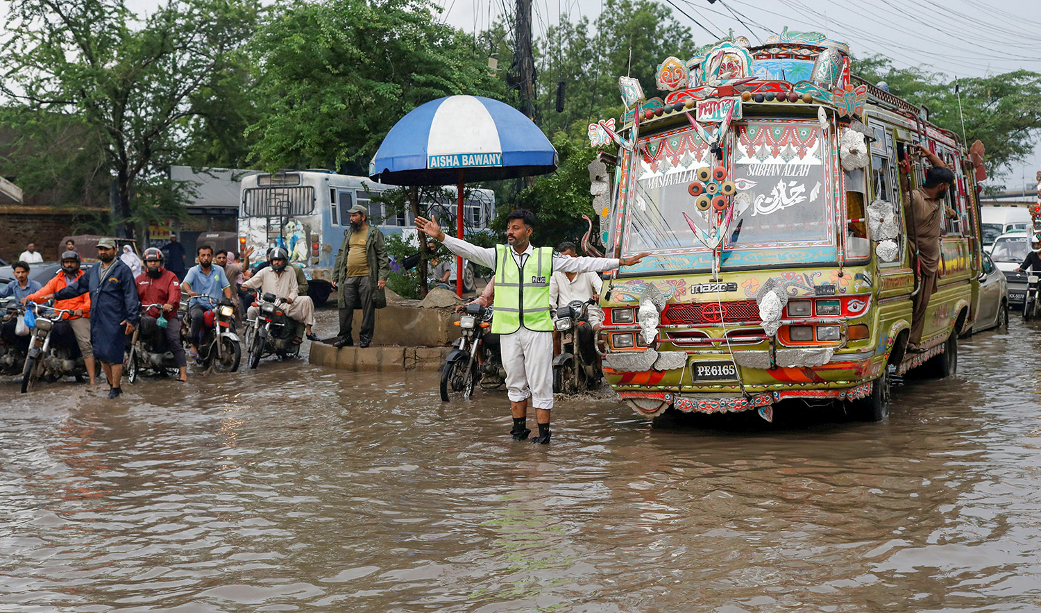 A police officer controls traffic while standing amid rain waters during the monsoon season in Karachi, Pakistan on August 10, 2022. (REUTERS)