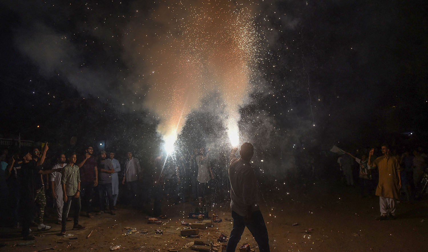 Youths hold lit fireworks during celebrations for Pakistan's 75th anniversary of Independence Day in Karachi on August 14, 2022. (AFP)