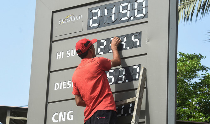 An employee of a petrol station updates the latest fuel prices on a board in Karachi on June 16, 2022, after a hike in prices of petroleum products by the government. (AFP/ File)