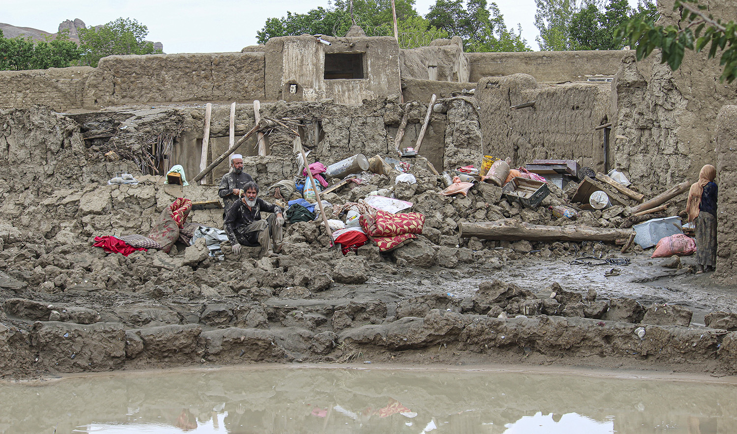 People collect their belongings from their damaged homes after heavy flooding in the Khushi district of Logar province south of Kabul, Afghanistan, on August 21, 2022. (AP)