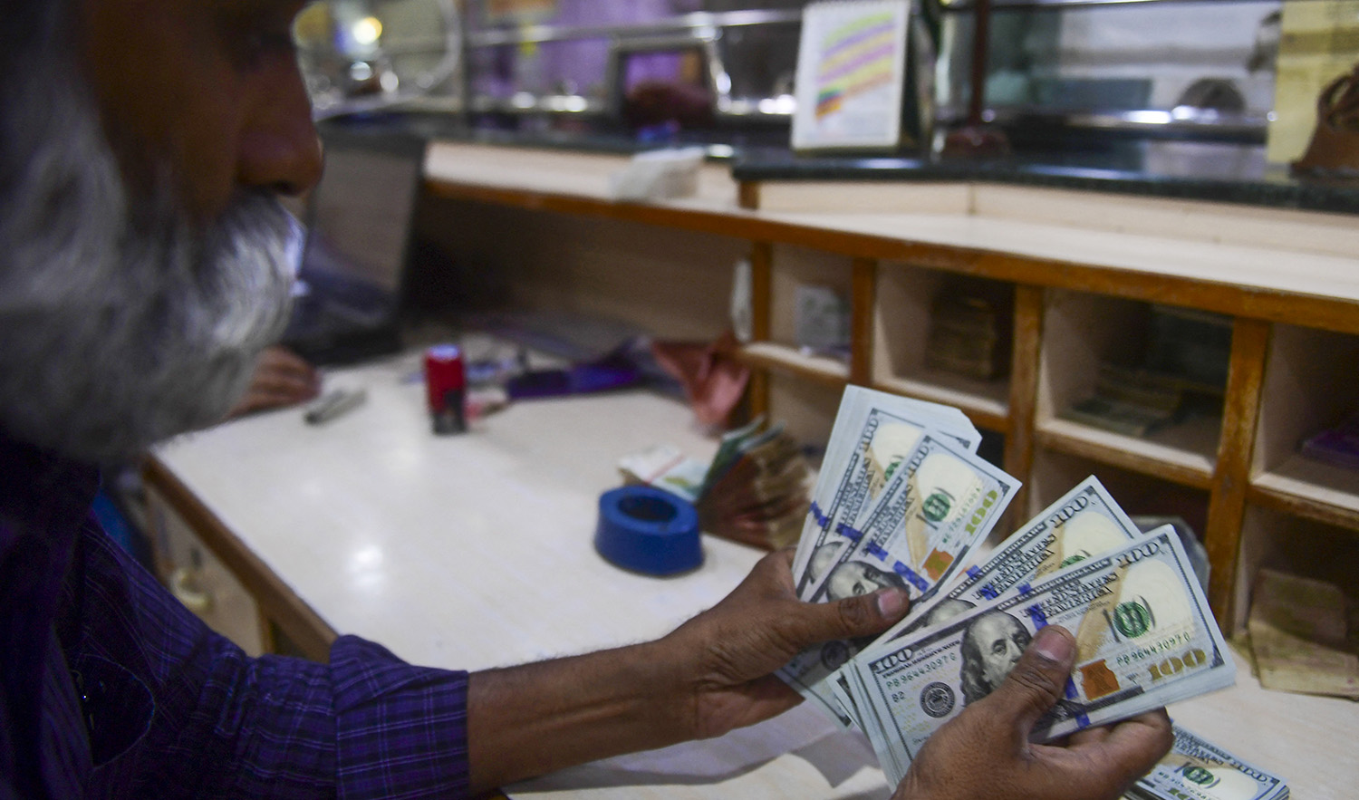 A foreign currency dealer counts US dollars at a shop in Karachi, Pakistan on May 19, 2022. (AFP/File)