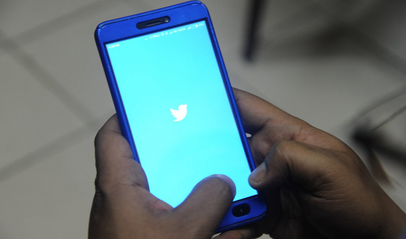 An Indian man poses for a photograph using Twitter on his cellpohne in Siliguri on March 27, 2018. (AFP/File)