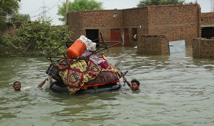 Residents move their belongings from their submerged houses after heavy monsoon rainfall in the flood affected area of Rajanpur district in Punjab province on August 24, 2022. (AFP)