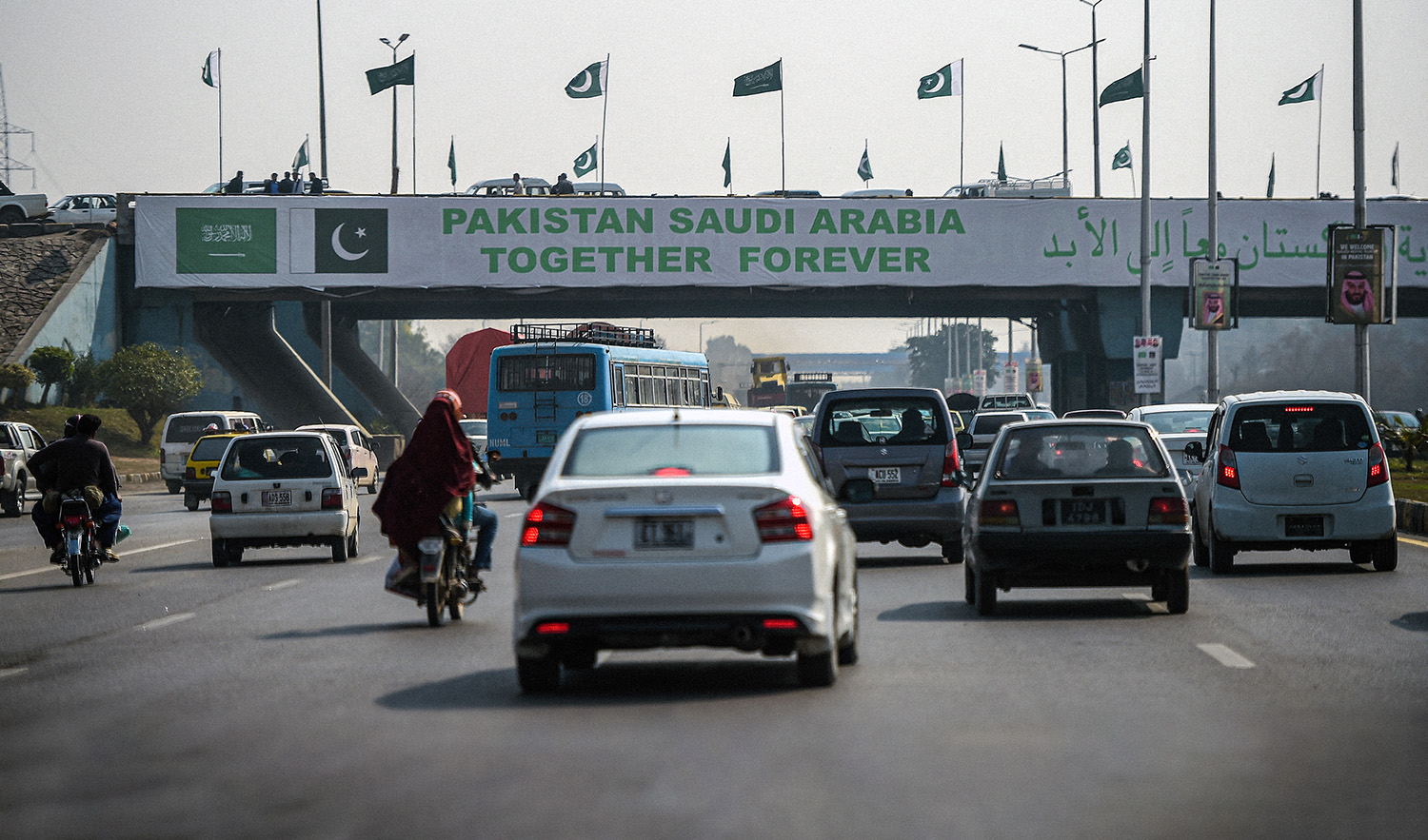 Pakistani commuters drive their vehicles under a banner welcoming Saudi Arabian Crown Prince Mohammed bin Salman displayed on a bridge, ahead of his arrival, in Islamabad on February 15, 2019. (AFP/File)