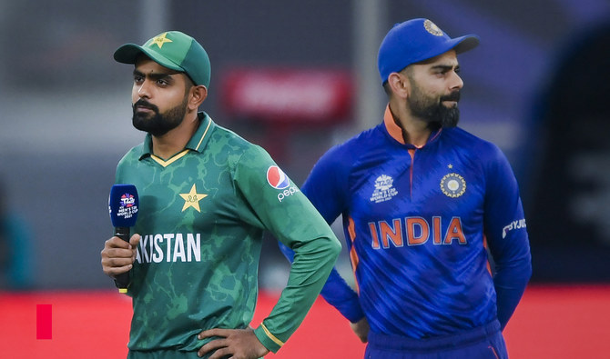 Former India's captain Virat Kohli, right, and his Pakistani skipper Babar Azam arrive on the field for toss before the start of the ICC men’s Twenty20 World Cup cricket match at the Dubai International Cricket Stadium on October 24, 2021. (AFP/File)