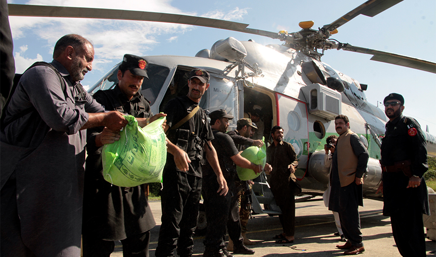 Frontier constabularies load food to a helicopter for flood-affected people, in Swat valley, Pakistan, Aug. 28, 2022. (AP)