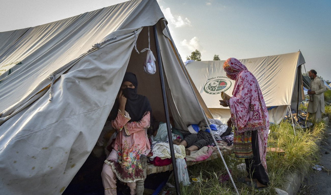 A displaced family prepares to drink tea at a makeshift camp after fleeing from their flood hit home following heavy monsoon rains in Charsadda district of Khyber Pakhtunkhwa on August 29, 2022. (AFP)