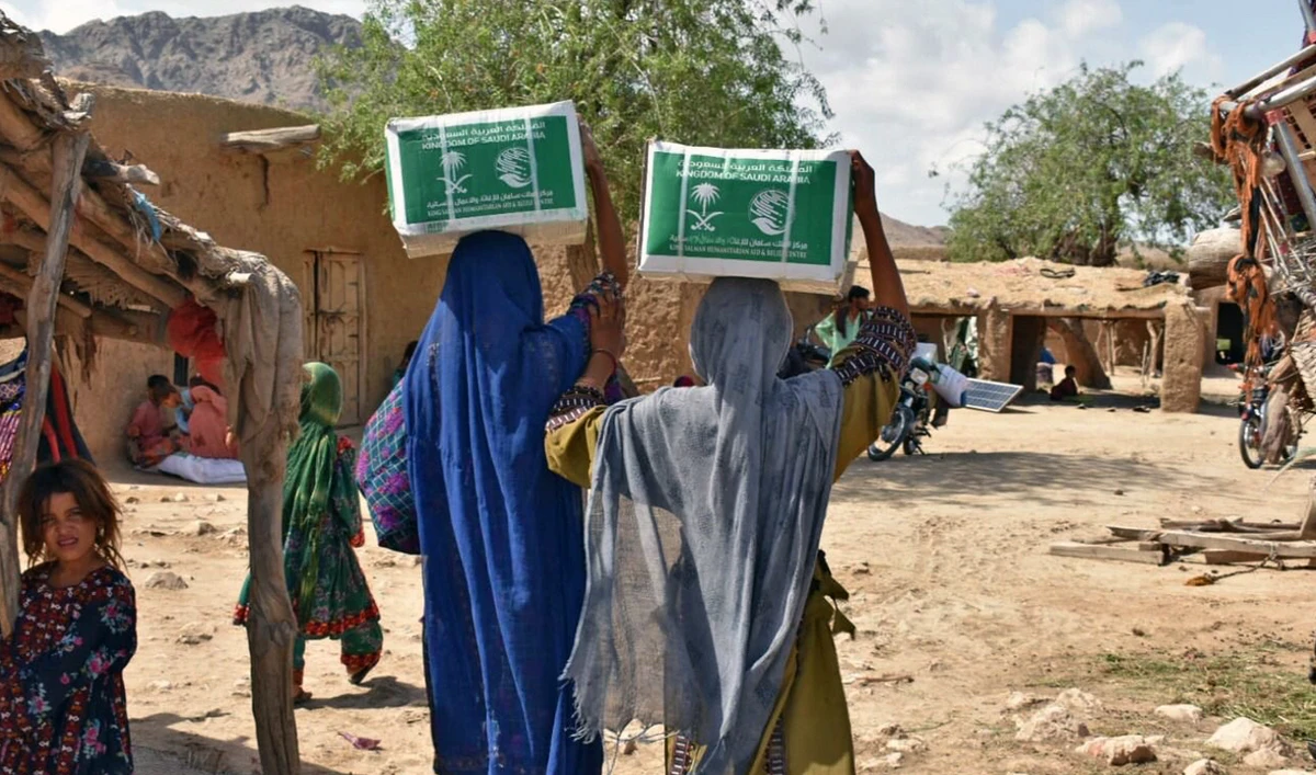 Flood affectees of Balochistan are carrying relief food packages provided by the KSRelief in Khuzdar, Pakistan on July 15, 2022. (KSRelief)