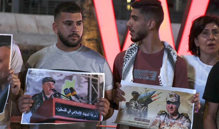Palestinians hold placards depicting slain Islamic Jihad commander Tayseer Al-Jabari as they demonstrate in the West Bank city of Ramallah on Aug. 5, 2022 against Israeli strikes in Gaza. (AFP)