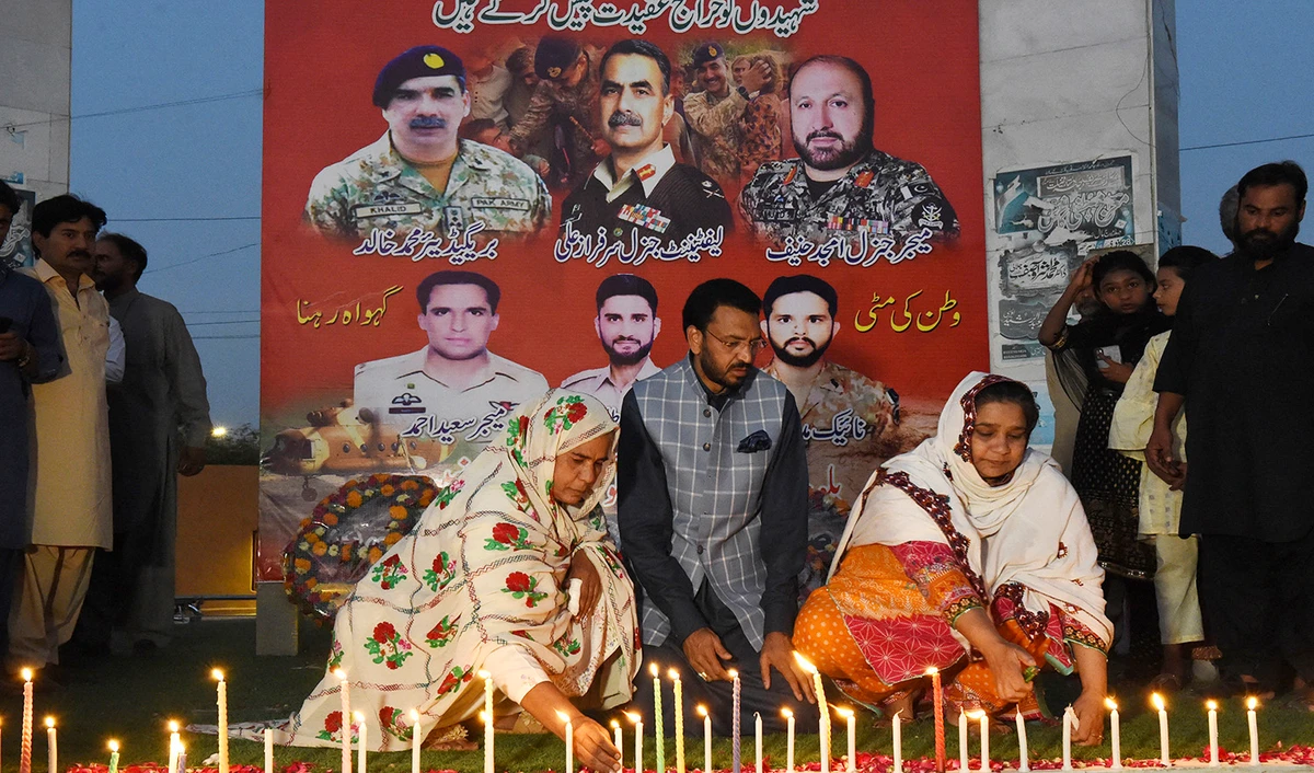Residents light candles to pay tribute to Pakistan's servicemen, who lost their lives in a helicopter crash, in Quetta on August 3, 2022. (AFP)