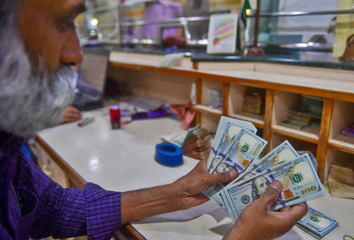 A foreign currency dealer counts US dollars at a shop in Karachi, Pakistan, on May 19, 2022. (AFP/File)