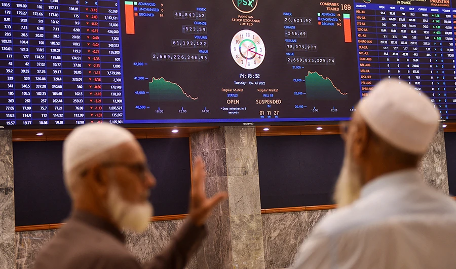 Stockbrokers speak while monitoring the share prices during a trading session at the Pakistan Stock Exchange (PSX) in Karachi on July 19, 2022. (AFP/FILE)