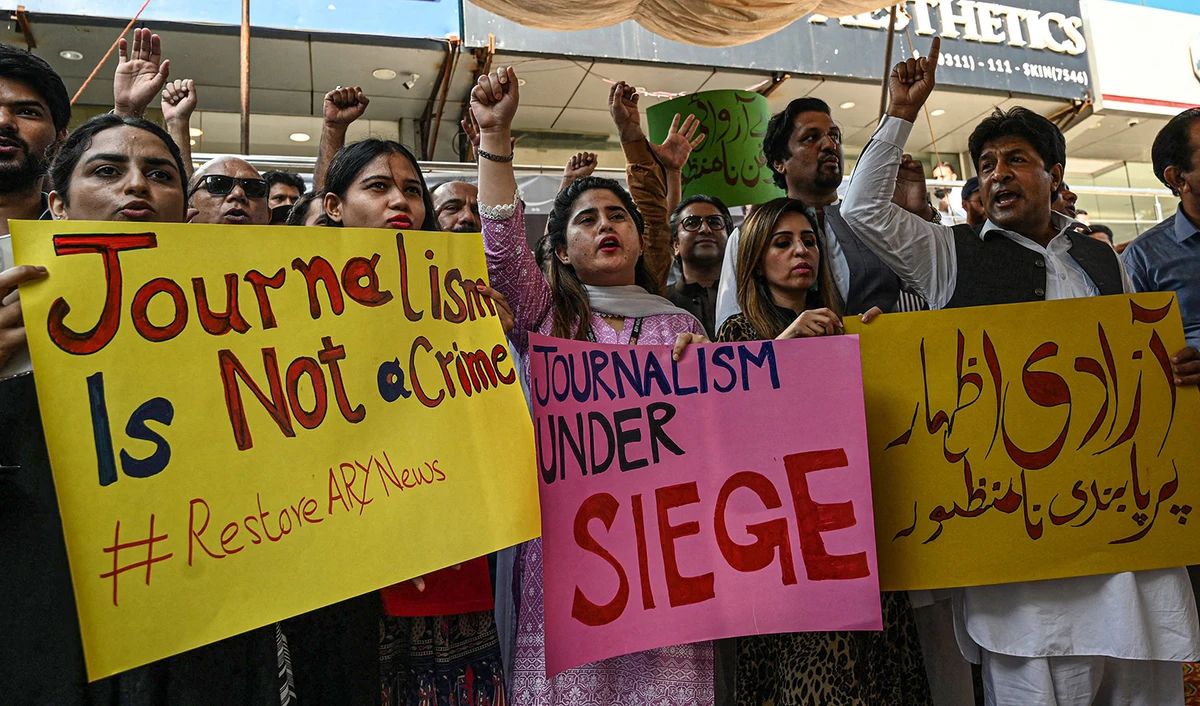 Journalists and employees of ARY News chant slogans and hold placards during a protest against the channel being taken off air by the government in Islamabad, Pakistan, on August 12, 2022. (AFP)