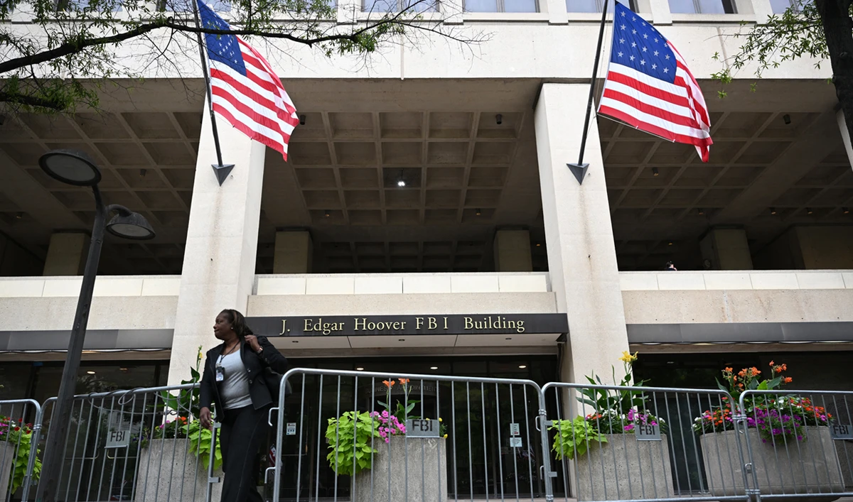 A person passes through police barricades surrounding the J. Edgar Hoover FBI building in Washington, DC, on August 15, 2022. (AFP)