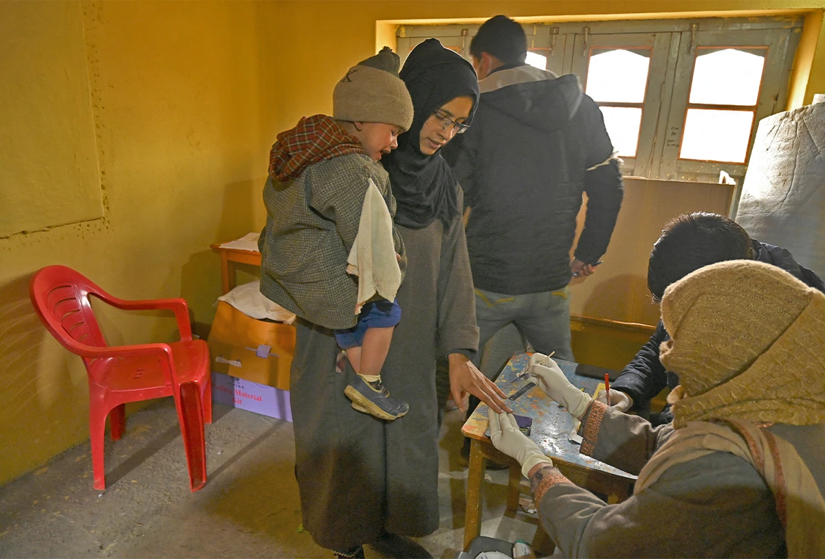 An election official marks the finger of a voter with indelible ink prior to casting ballot during the second phase of the District Development Council (DDC) and Panchayat by-elections at a polling station in Najan Sumbal area of Bandipora district on December 1, 2020. (AFP/File)