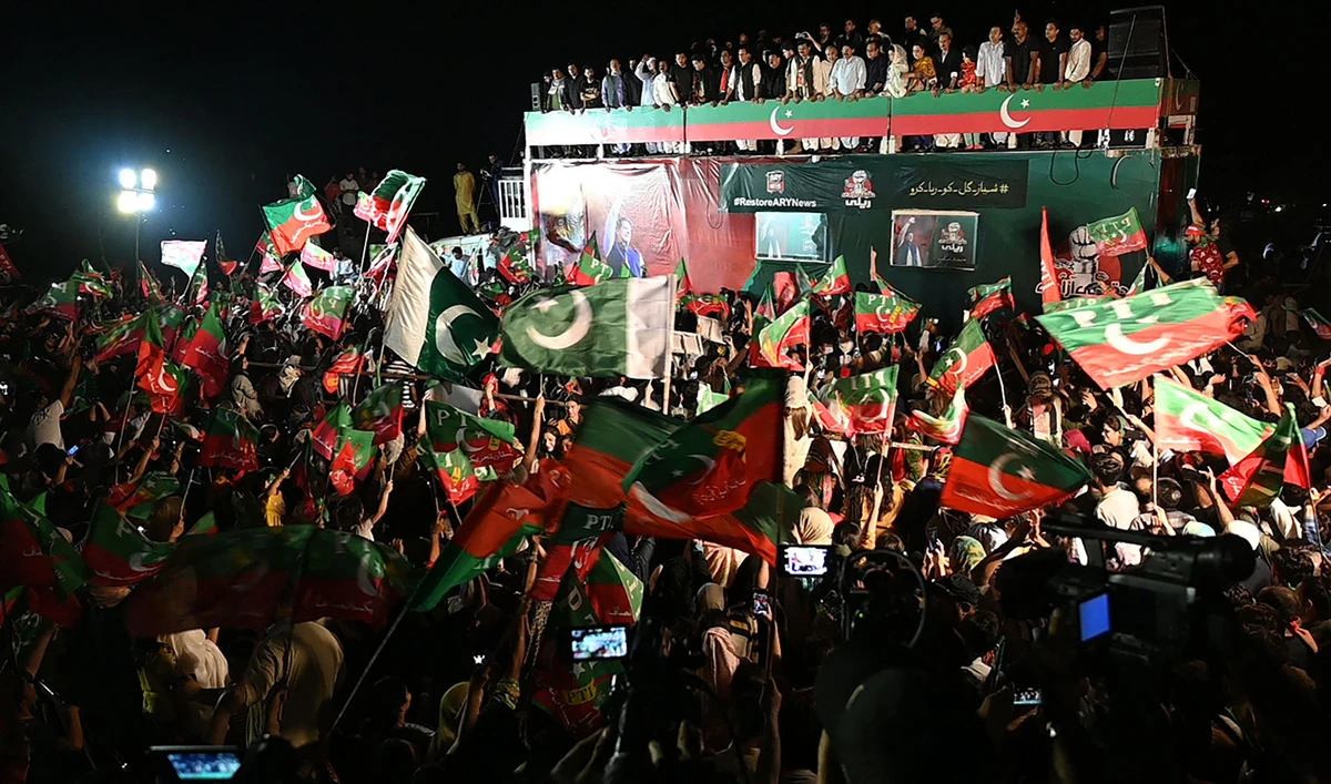 Supporters of Pakistan's former Prime Minister and leader of the Pakistan Tehreek-e-Insaf party (PTI) Imran Khan, wave flags during a protest rally in Islamabad on August 20, 2022. (AFP)