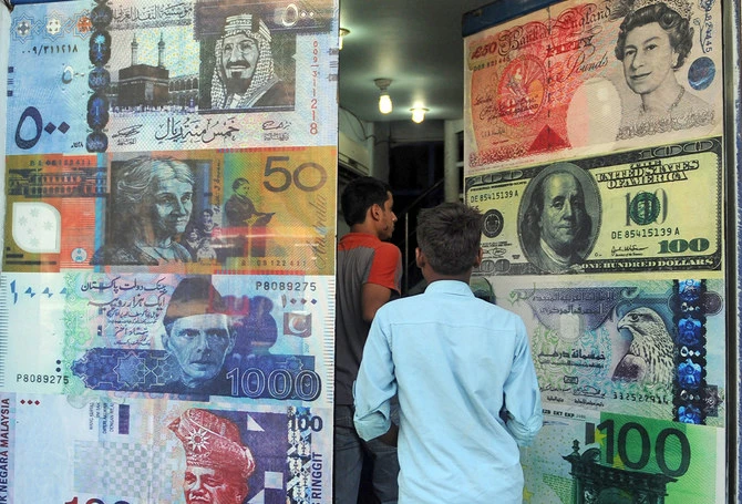 Pakistani customers enter a foreign currency exchange shop in Karachi, Pakistan, on October 14, 2010. (AFP/ File)