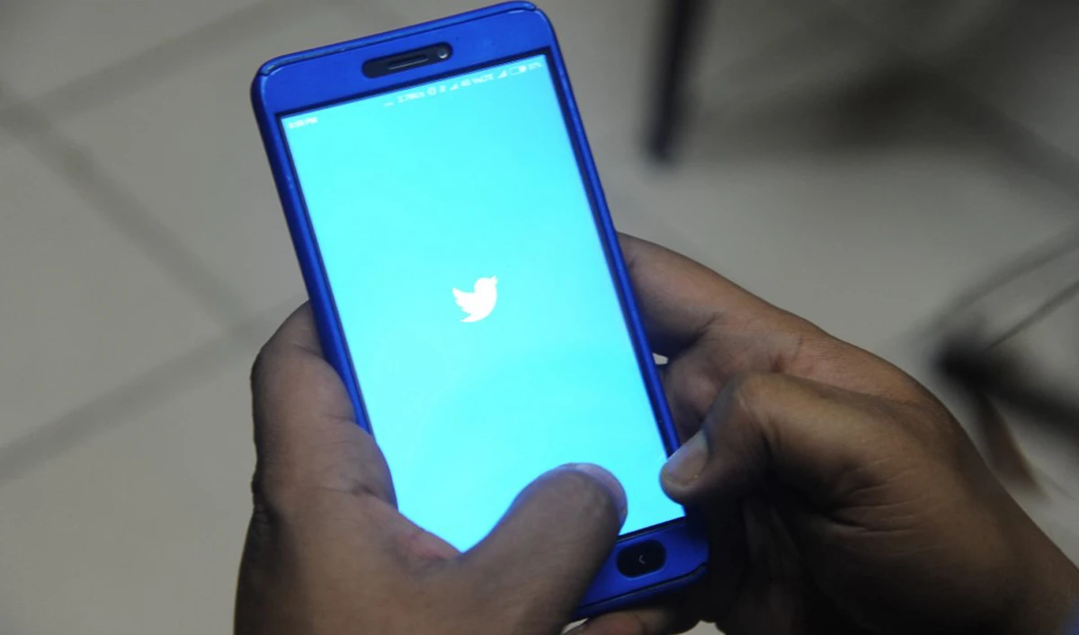An Indian man poses for a photograph using Twitter on his cellpohne in Siliguri on March 27, 2018. (AFP/File)