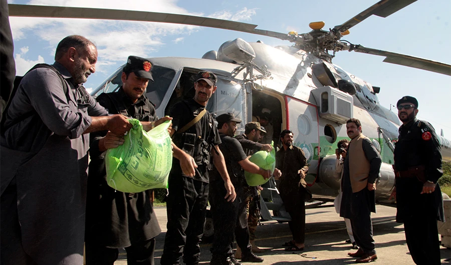 Frontier constabularies load food to a helicopter for flood-affected people, in Swat valley, Pakistan, Aug. 28, 2022. (AP)
