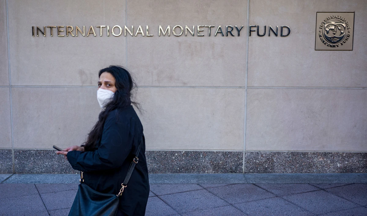 A woman walks past the International Monetary Fund (IMF) headquarters building in Washington, DC on March 11, 2022. (AFP/File)