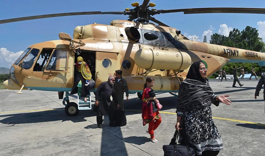 Stranded local tourists disembark from a Pakistan army helicopter after they were rescued by army from the flood-hit tourist areas in Saidu Sharif, the capital of Swat valley in the Khyber Pakhtunkhwa province on August 30, 2022. (AFP)
