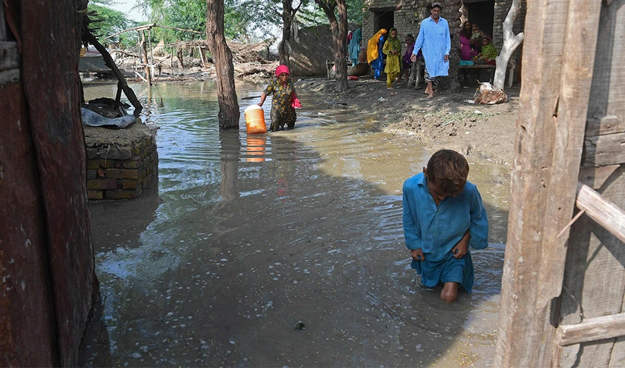 Flood-affected people gather outside their flooded houses at Shikarpur in Sindh province on August 30, 2022. (AFP)