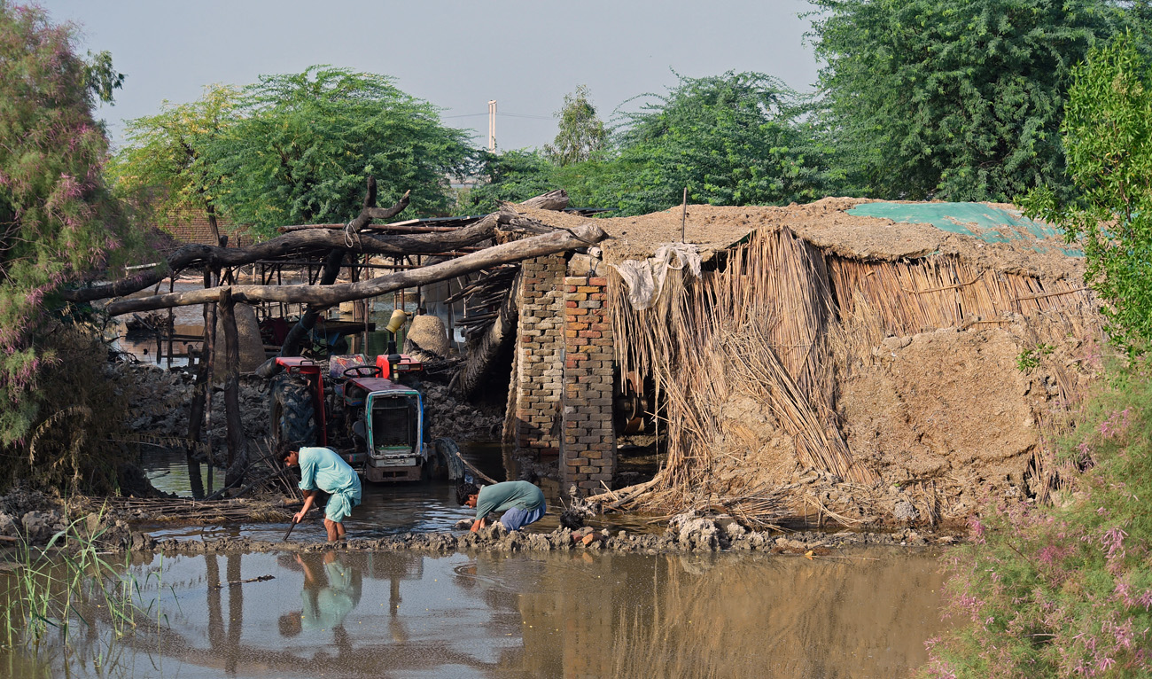Flood affected people work to avoid flood waters entering their damaged houses following heavy monsoon rains at Shikarpur in Sindh province on August 30, 2022. (AFP/File)