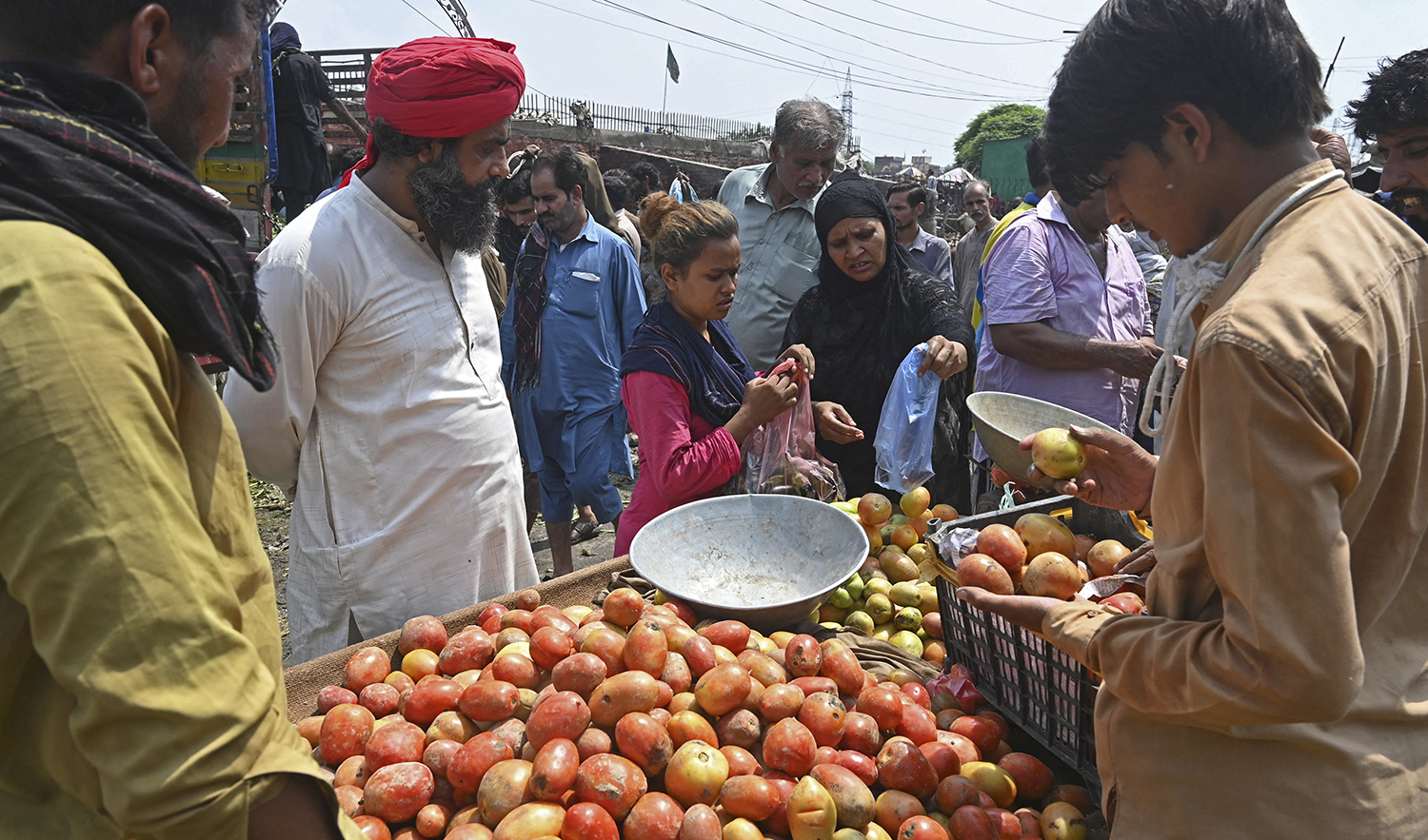 People buy fruits at a local market in Lahore, Pakistan, on August 30, 2022. (AFP)