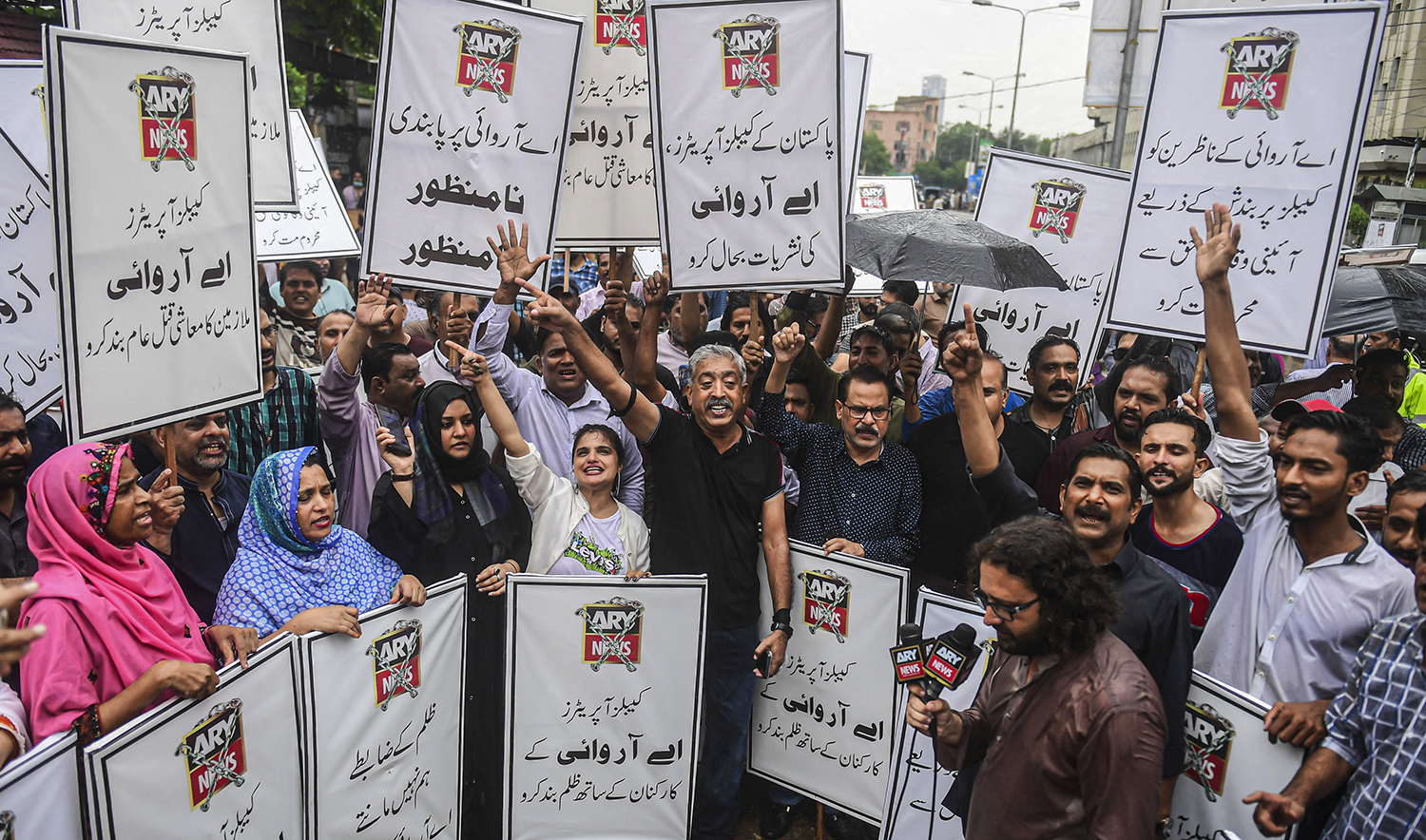 Journalists and employees of ARY News carry placards as they chant slogans during a protest against the channel being taken off air by the government in Karachi, Pakistan, on August 16, 2022. (AFP/File)