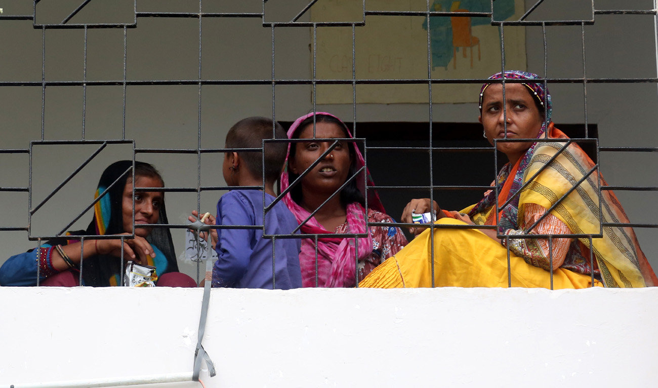 Women sit in a corridor inside Govt. Boys Sindhi Primary School in Sachal Goth, Karachi, Pakistan, on September 1, 2022. (AN Photo)