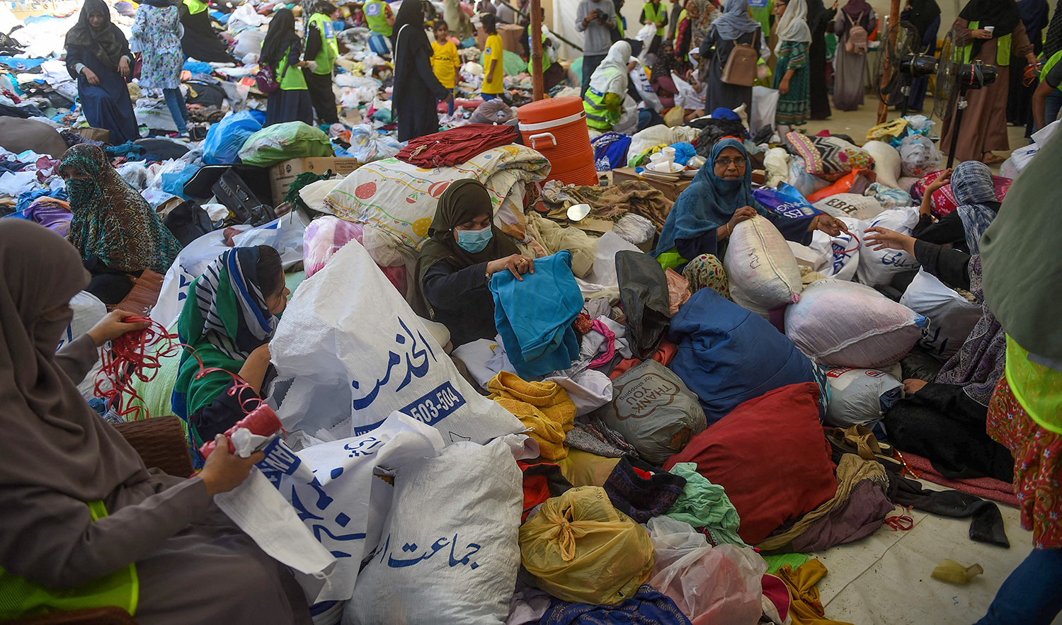 Volunteers of the Charity Al-Khidmat Foundation prepare relief bags for flood-affected people in Karachi, Pakistan on September 3, 2022. (AFP)