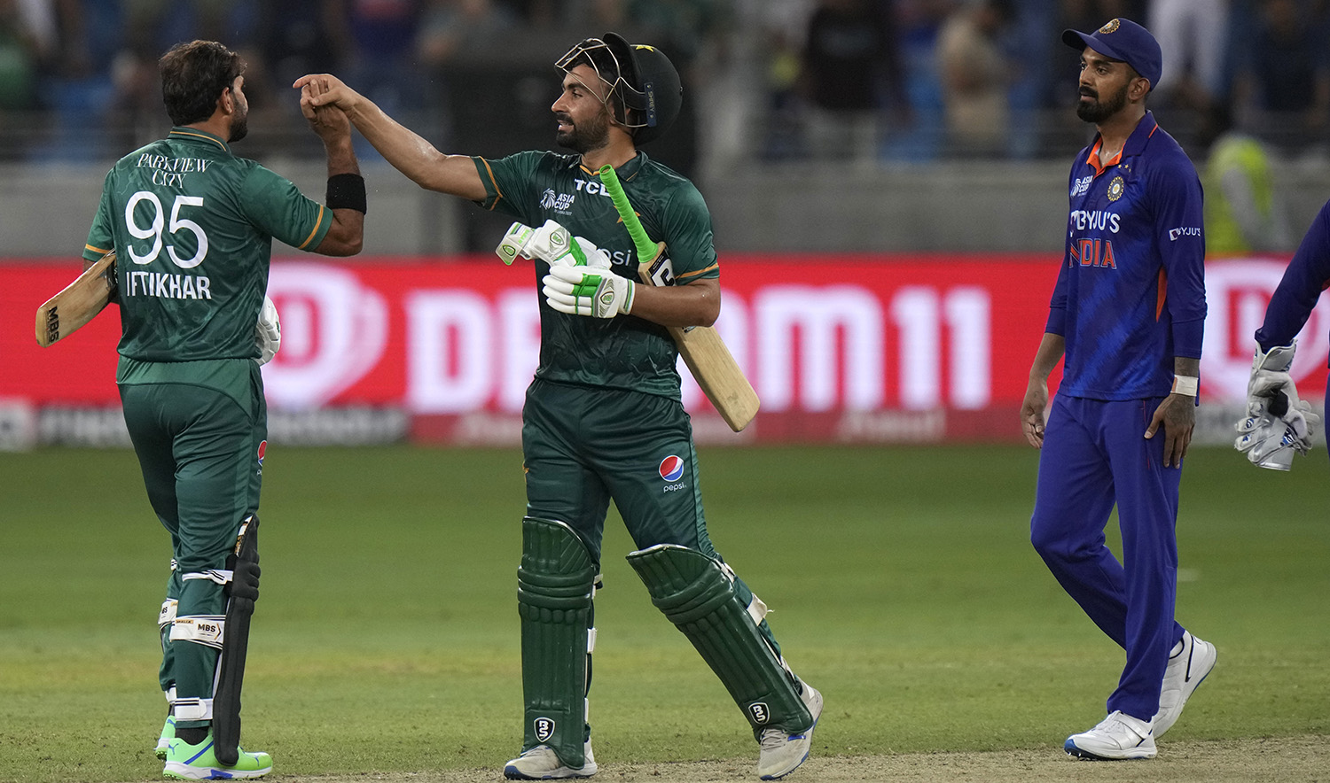 India's KL Rahul, right, watches as Pakistan's Iftikhar Ahmed, left, celebrates with batting partner Khushdil Shah after their win in the T20 cricket match of Asia Cup against India, in Dubai, United Arab Emirates, on September 4, 2022. (AP)